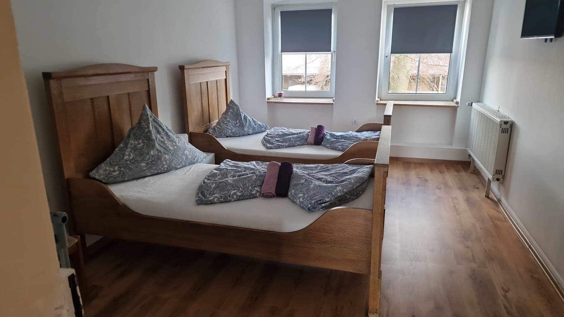 Zweibettzimmer mit Holzbetten und Laminatboden.